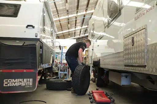 Caravan wheel maintenance in progress: Technician ensures smooth operation