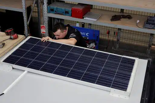 Caravan solar panel maintenance: Technician ensures peak efficiency indoors
