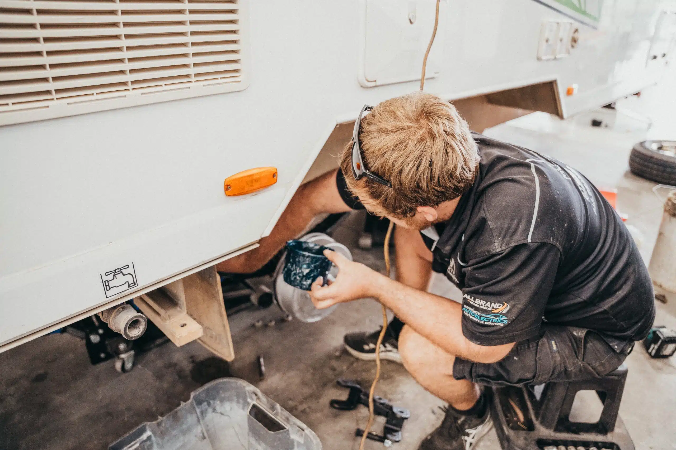 Caravan wheel maintenance underway: Technician services brakes, tires, or bearings