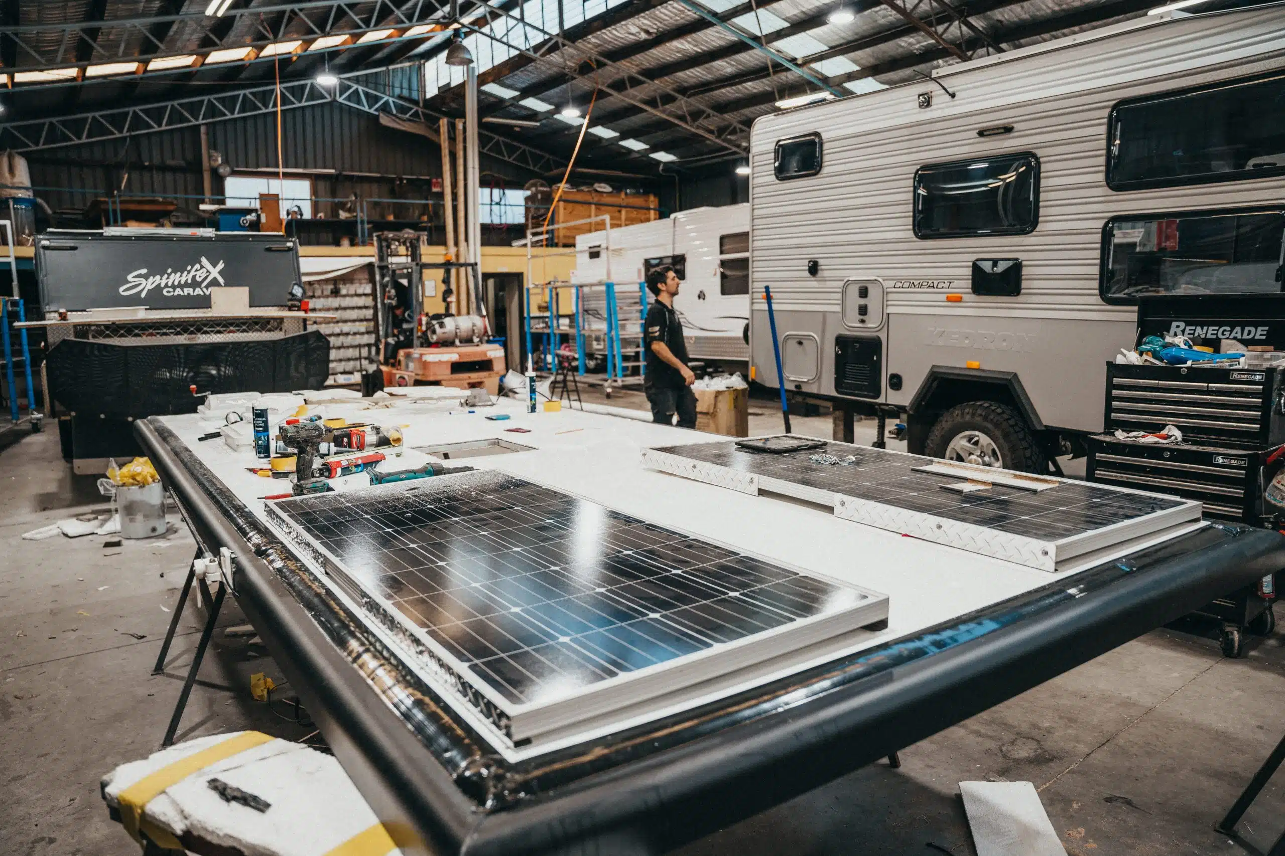 Caravan solar panel maintenance: Technician inspects or repairs panels for optimal performance